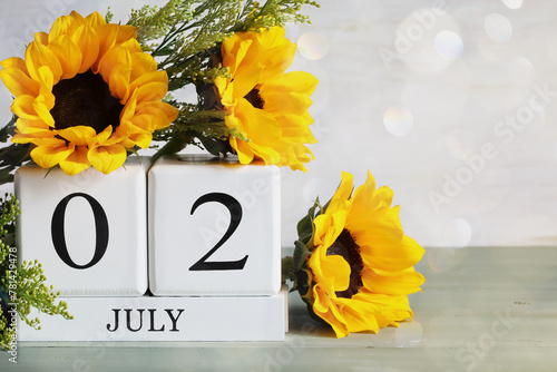 Special Recreation for the Disabled Day. White wood calendar blocks with the date July 2nd and beautiful sunflower bouquet with bokeh. Selective focus with blurred background. 