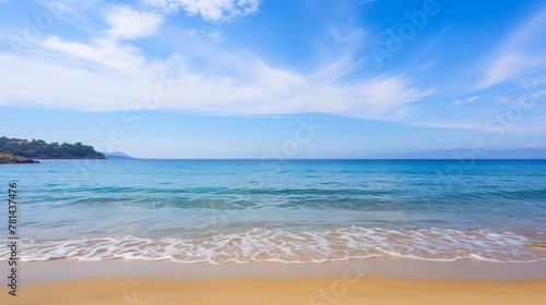 The ocean is calm and the sky is clear. The beach is empty and the water is a beautiful blue color
