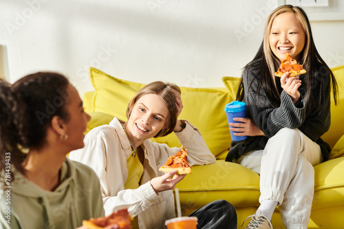 A diverse group of teenage girls sit together on a vibrant yellow couch, symbolizing friendship and togetherness.