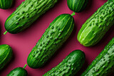 Fresh green cucumbers on a vibrant red surface with water droplets, organic and healthy farm produce concept