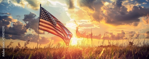 American flag waving in the field at sunset with cloudy sky. Patriotic concept with natural background