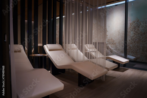 Serene, modern relaxation setting at luxury hotel in Zermatt, Switzerland. Sleek white lounge chairs on dark wooden floor, private and stylish. Sophisticated, tranquil ambiance for unwinding.