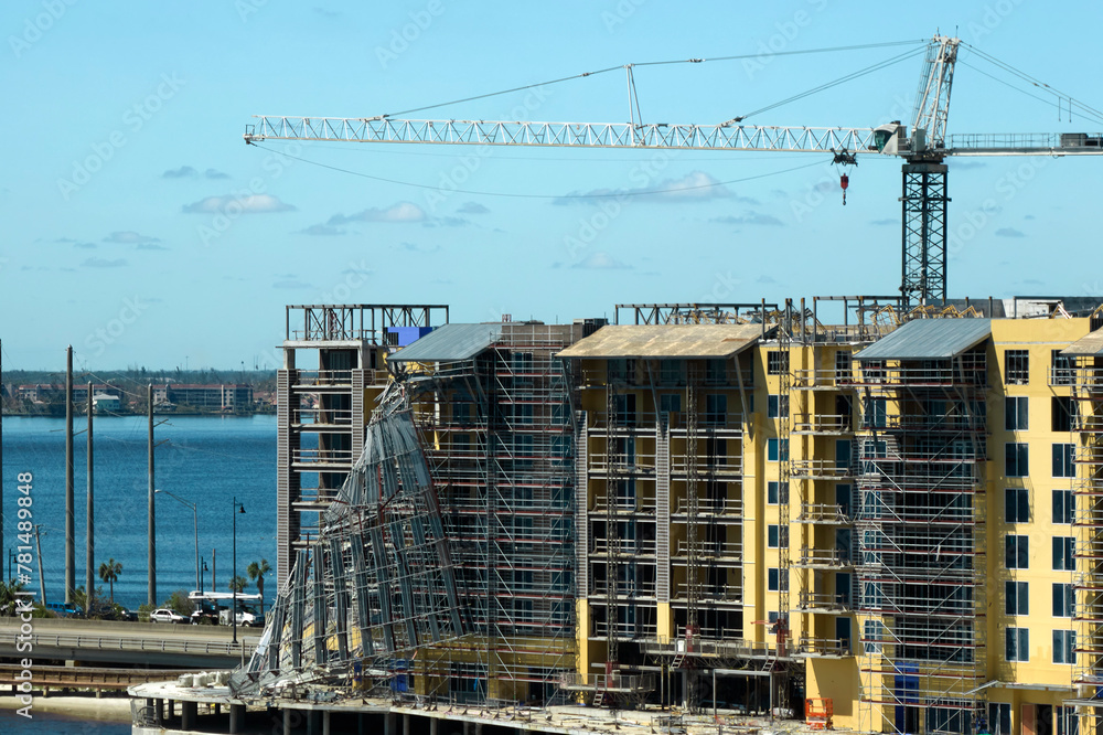 Aerial view of ruined by hurricane Ian construction scaffolding on high apartment building site in Port Charlotte, USA