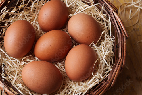 Overhead view of brown chicken eggs in wicker basket