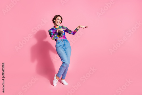 Full size photo of nice young woman arms dance empty space wear pullover isolated on pink color background © deagreez