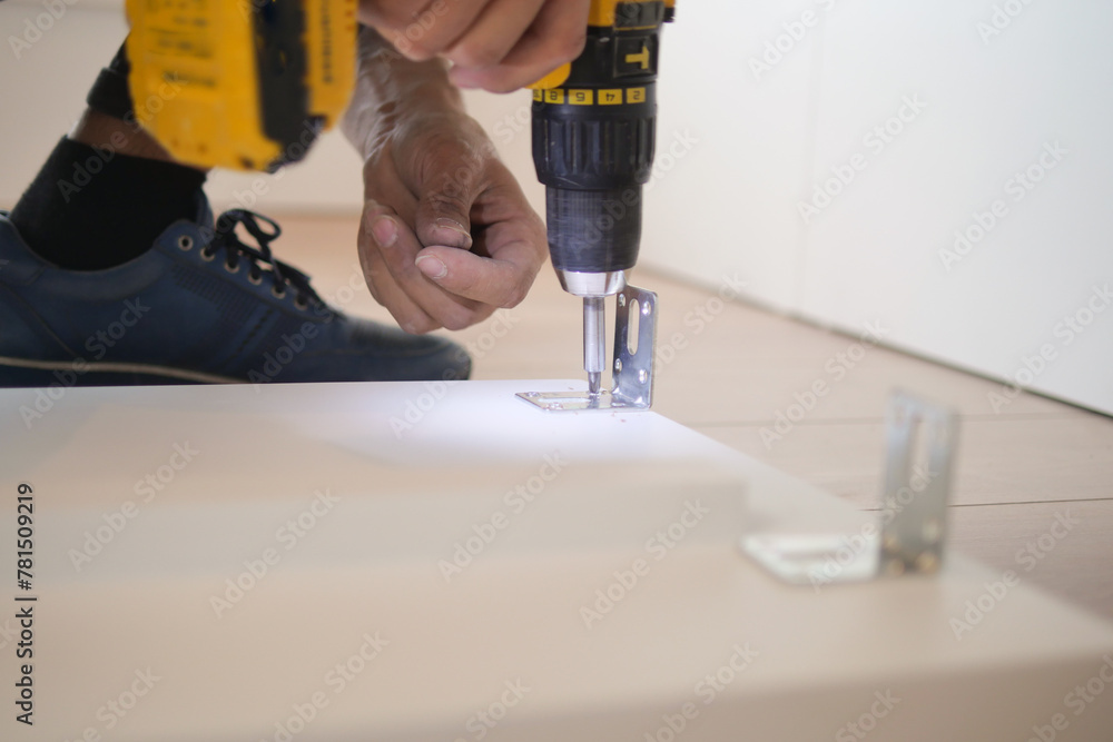  using electric drilling on white wooden board 