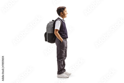 Full length profile shot of a schoolboy in a uniform standing with hands inside pockets