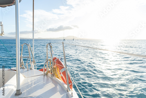 Exterior View of a Catamaran in the Ocean on a Sunny Day, with Coastal Mountains in the Background