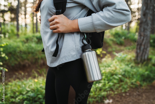 Close up of metal water bottle for hiking hanging from backpack