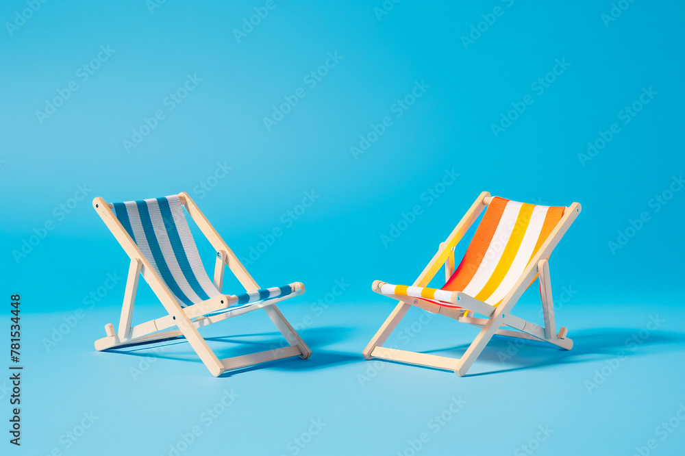 Two Striped Deck Chairs on a Bright Blue Background, Summer Relaxation Concept