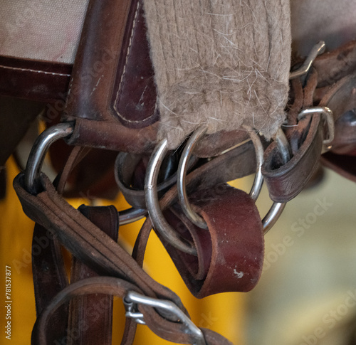 close up of string and leather straps of pack girth and strap metal round rings and buckles brown leather and string girth tack for horse packing vertical image  photo