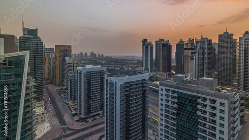 Sunrise view of various skyscrapers and towers in Dubai Marina from above aerial timelapse