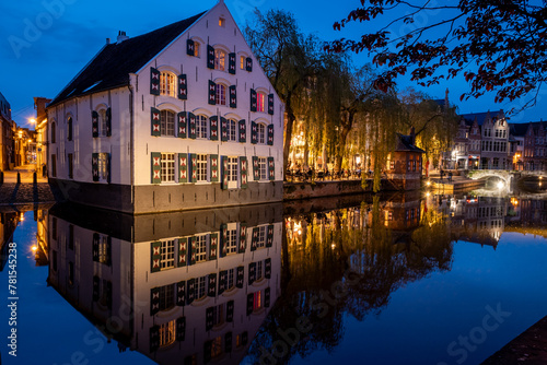 Lier city in Belgium at night. warm lights reflect evening water people eat and drink in street old houses historic building Buyldragershuisje and de fortuin. nightlife on Feix timmermansplein square © drew
