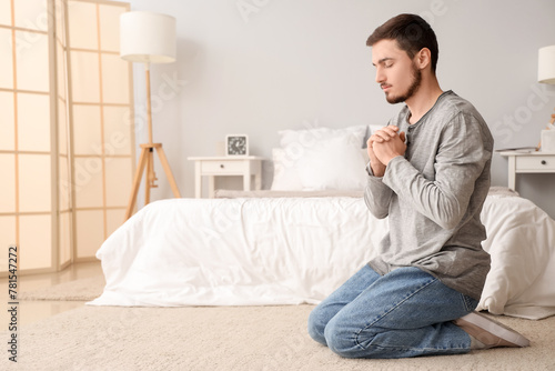 Young man praying on floor ...