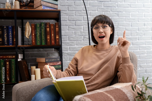 Young woman with book point...
