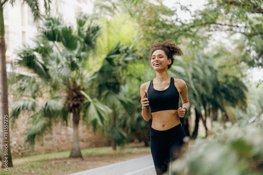 Active woman athlete is jogging in morning on natural parkland background. Healthy life concept Active woman athlete is jogging in morning on natural parkland background. Healthy life concept