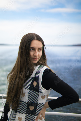 a pensive dreamy young woman sails on a ship on an alpine lake against the backdrop of mountains.beautiful brunette is sad and dreams, enjoying nature. © Daria