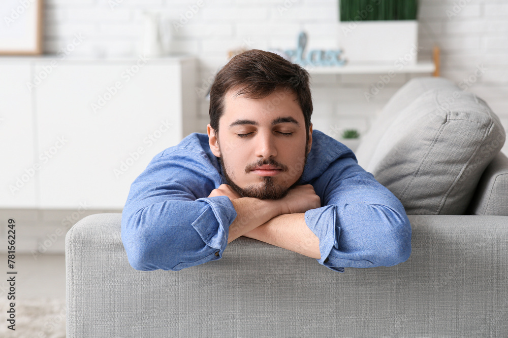 Tired young man sleeping on couch at home Tired young man sleeping on couch at home