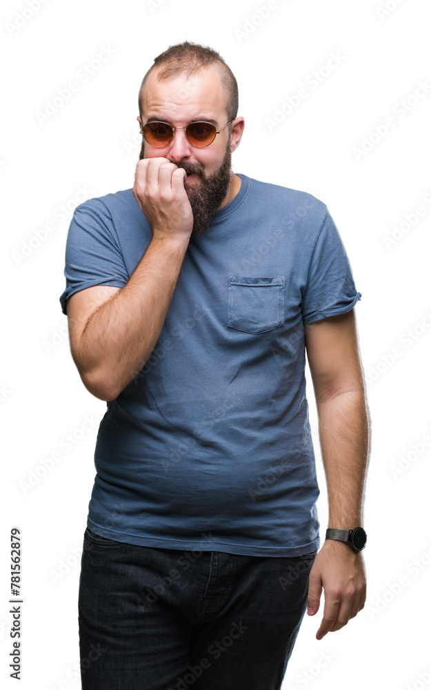 Young caucasian hipster man wearing sunglasses over isolated background looking stressed and nervous with hands on mouth biting nails. Anxiety problem. Young caucasian hipster man wearing sunglasses over isolated background looking stressed and nervous with hands on mouth biting nails. Anxiety problem.