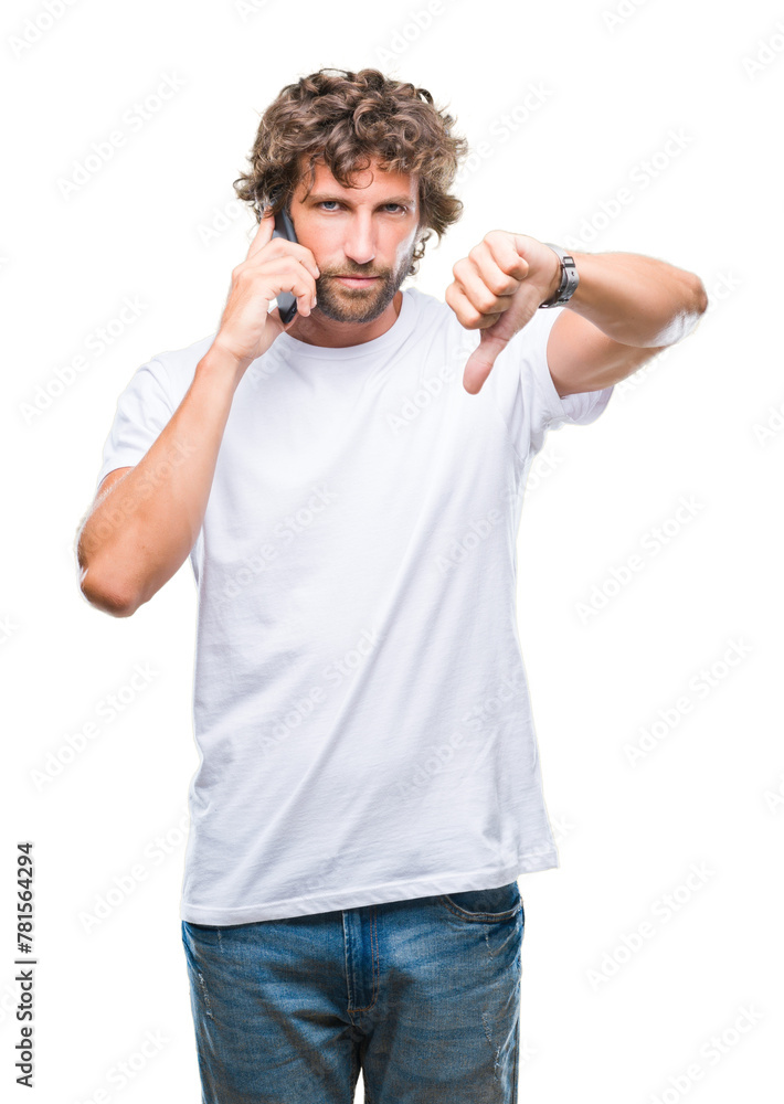 Handsome hispanic man model talking on smartphone over isolated background with angry face, negative sign showing dislike with thumbs down, rejection concept Handsome hispanic man model talking on smartphone over isolated background with angry face, negative sign showing dislike with thumbs down, rejection concept