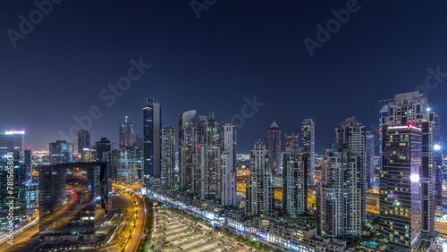 Modern residential and office complex with many towers aerial night timelapse at Business Bay, Dubai, UAE. © neiezhmakov