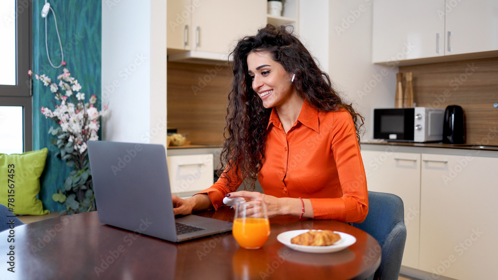 Happy woman making a video call on a laptop Happy woman making a video call on a laptop