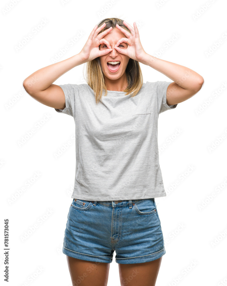 Fototapeta premium Young beautiful woman over isolated background doing ok gesture like binoculars sticking tongue out, eyes looking through fingers. Crazy expression.