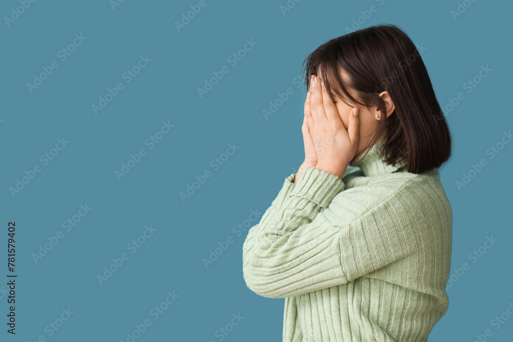 Beautiful young stressed woman on blue background. Stress Awareness Month Beautiful young stressed woman on blue background. Stress Awareness Month