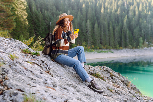 Young woman tourist uses a smartphone on the nature. Lifestyle, travel, tourism, active life.