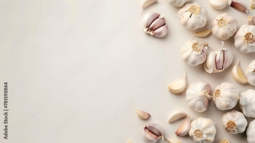 Fresh garlic bulbs scattered on a light grey surface.