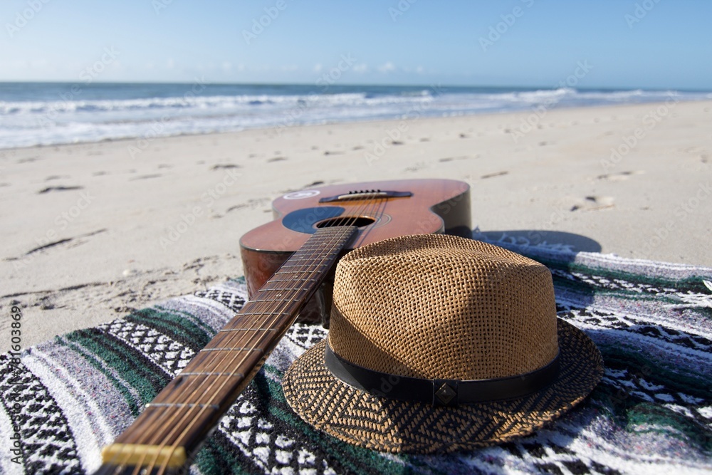 Guitar, blanket, and hat on the beach
