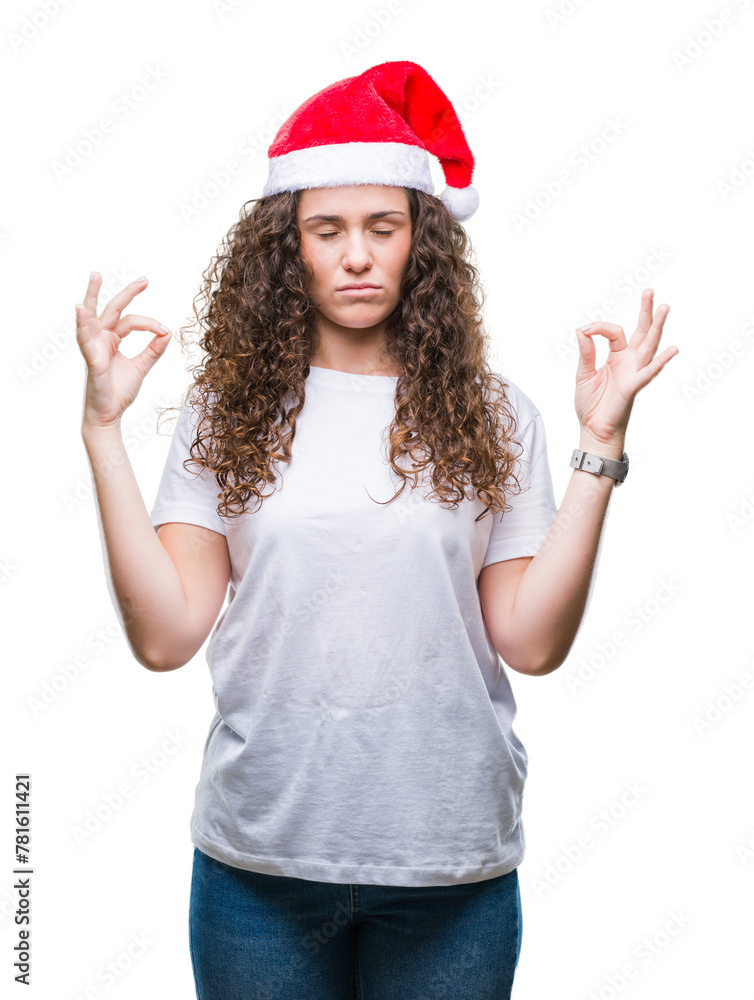 Young brunette girl wearing christmas hat over isolated background relax and smiling with eyes closed doing meditation gesture with fingers. Yoga concept. Young brunette girl wearing christmas hat over isolated background relax and smiling with eyes closed doing meditation gesture with fingers. Yoga concept.