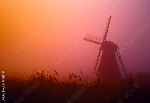 Windmill in the mist. A windmill rises from a misty field
