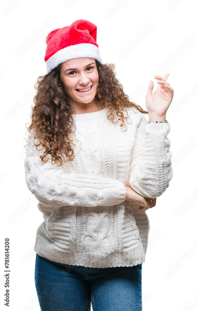 Young brunette girl wearing christmas hat over isolated background with a big smile on face, pointing with hand and finger to the side looking at the camera. Young brunette girl wearing christmas hat over isolated background with a big smile on face, pointing with hand and finger to the side looking at the camera.