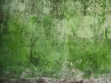 Grungy background featuring rough concrete surface of an old green wall