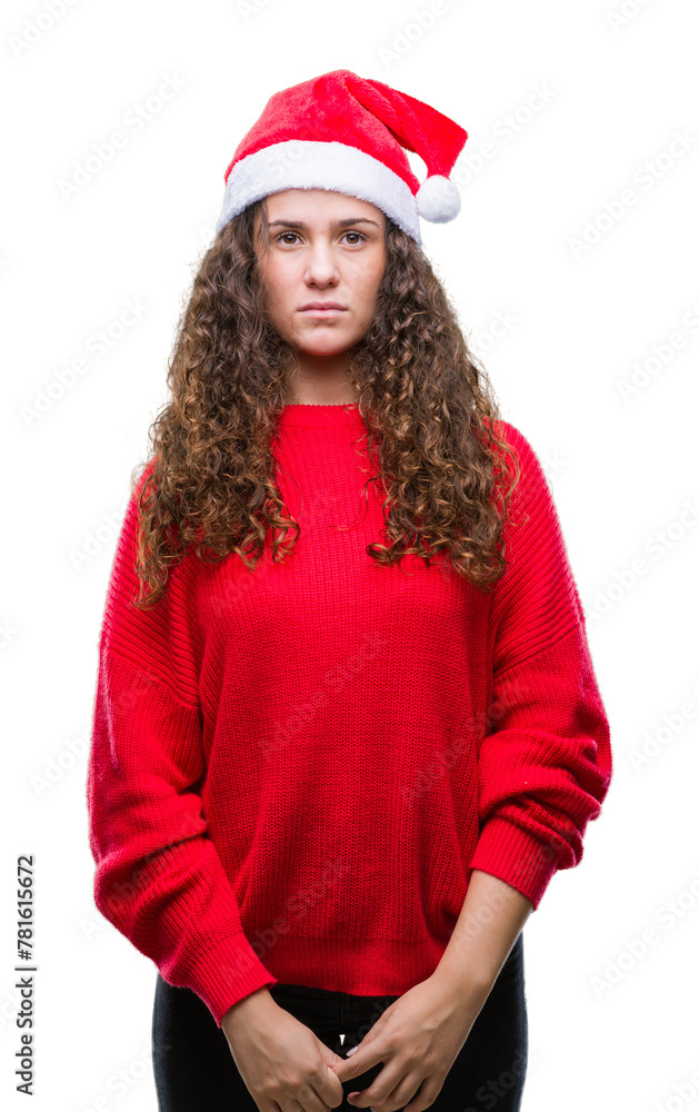Young brunette girl wearing christmas hat over isolated background with serious expression on face. Simple and natural looking at the camera. Young brunette girl wearing christmas hat over isolated background with serious expression on face. Simple and natural looking at the camera.