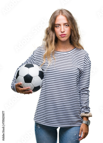 Beautiful young blonde woman holding soccer football ball over isolated background with a confident expression on smart face thinking serious
