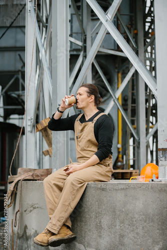 Lunch break, industrial worker drinking coffee while resting.