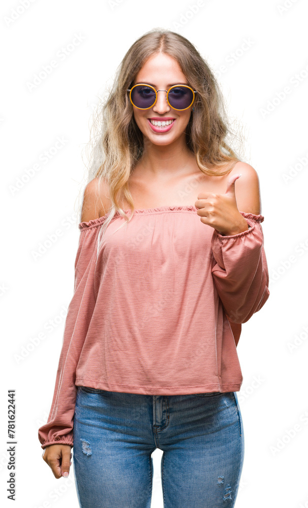 Beautiful young blonde woman wearing retro sunglasses over isolated background doing happy thumbs up gesture with hand. Approving expression looking at the camera with showing success. Beautiful young blonde woman wearing retro sunglasses over isolated background doing happy thumbs up gesture with hand. Approving expression looking at the camera with showing success.