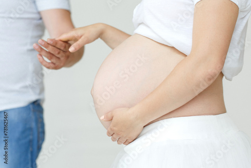 Pregnant Woman Holding Belly in Front of Man