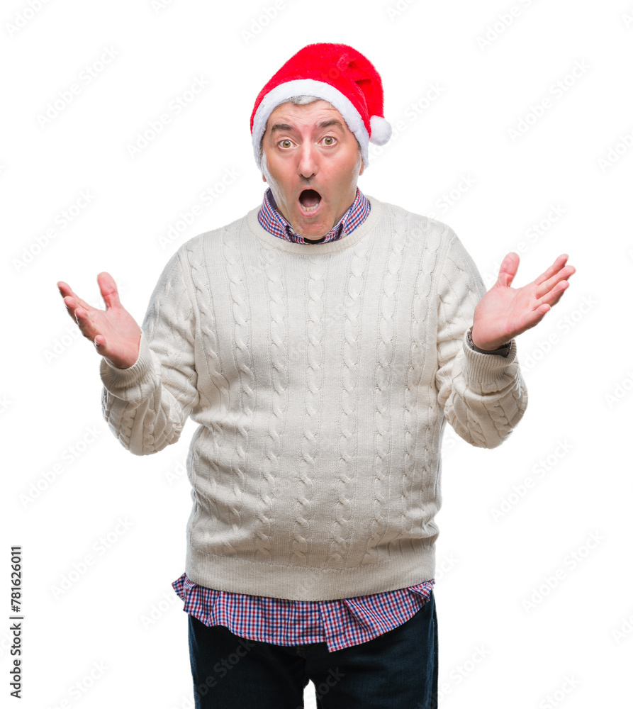 Naklejka premium Handsome senior man wearing christmas hat over isolated background celebrating crazy and amazed for success with arms raised and open eyes screaming excited. Winner concept