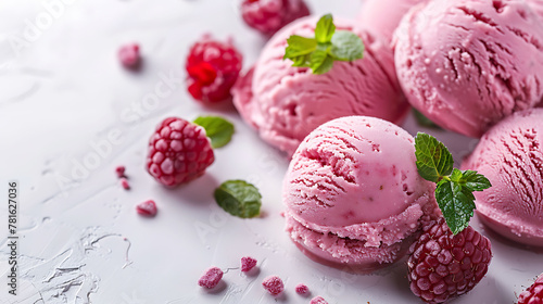 Raspberry sorbet scoops with mint on textured background. Close-up view of fruit gelato for dessert menu design photo