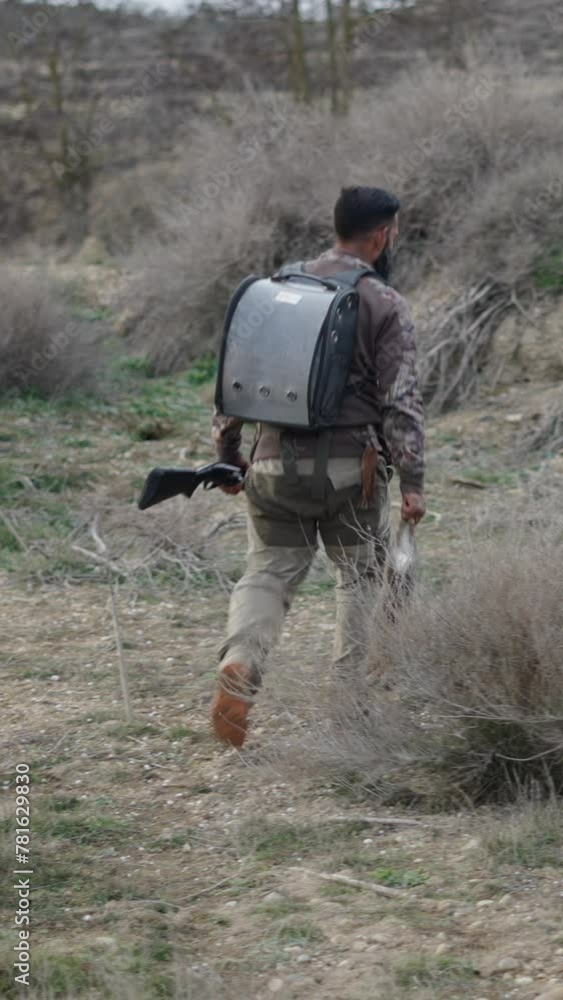Two unrecognizable hunters walking with a rabbit and a ferret Two unrecognizable hunters walking with a rabbit and a ferret