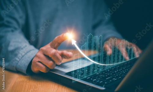 Concept of business prosperity and asset management, Businessman using laptop to analyze graph and point to business success, Real estate investment marketing analysis, Planning to increase profits.