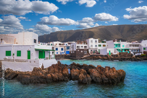 View of Punta Mujeres Village with white houses, on the coast of Lanzarote Island at the foot of the volcanic mountain in Canary Islands, Spain