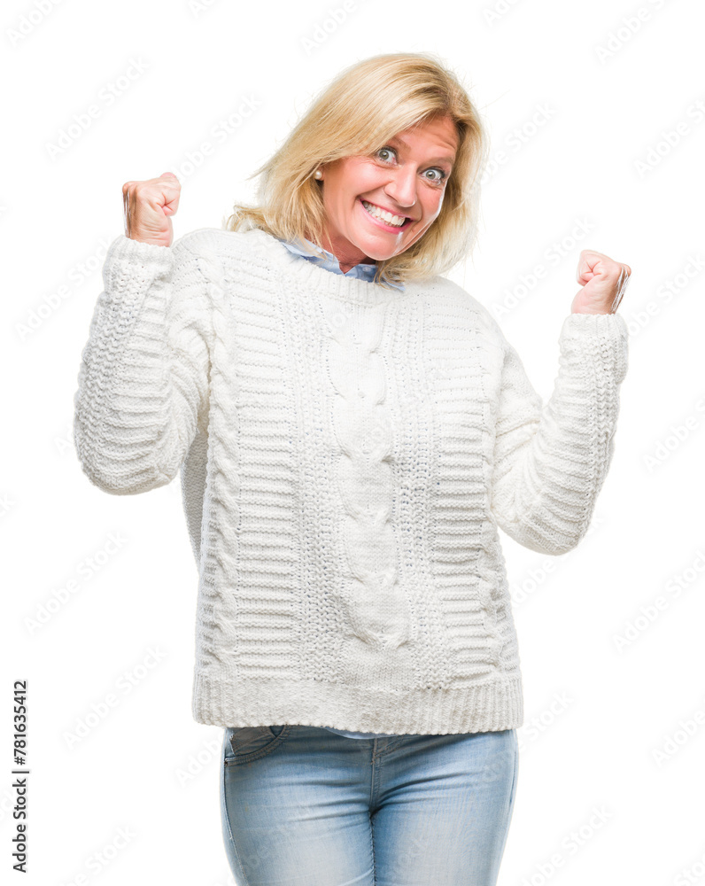 Middle age blonde woman wearing winter sweater over isolated background very happy and excited doing winner gesture with arms raised, smiling and screaming for success. Celebration concept. Middle age blonde woman wearing winter sweater over isolated background very happy and excited doing winner gesture with arms raised, smiling and screaming for success. Celebration concept.