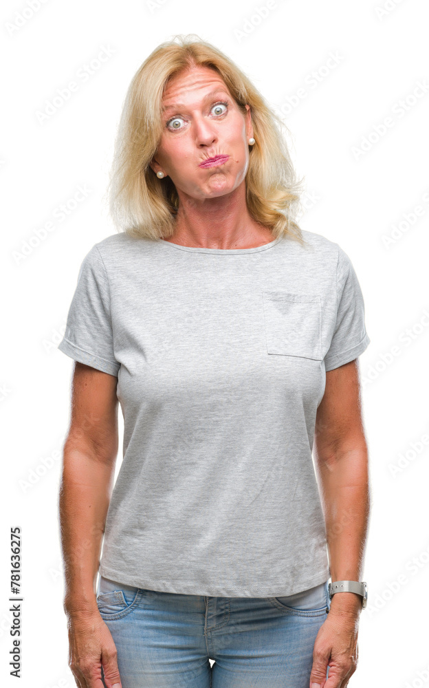 Middle age blonde woman over isolated background puffing cheeks with funny face. Mouth inflated with air, crazy expression. Middle age blonde woman over isolated background puffing cheeks with funny face. Mouth inflated with air, crazy expression.