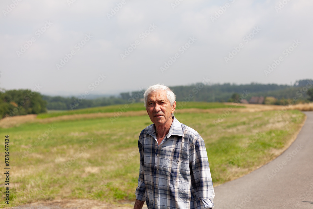 Peaceful and contemplative nature of an elderly man taking a leisurely walk along a rural road, embracing the beauty and simplicity of countryside living Peaceful and contemplative nature of an elderly man taking a leisurely walk along a rural road, embracing the beauty and simplicity of countryside living