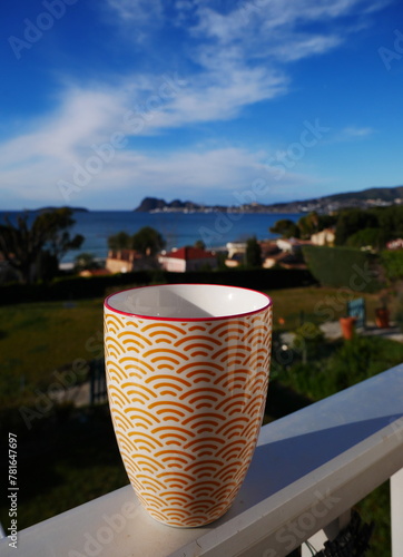 Close-up of a cup of coffee with the sea in the background at Cassis, France.