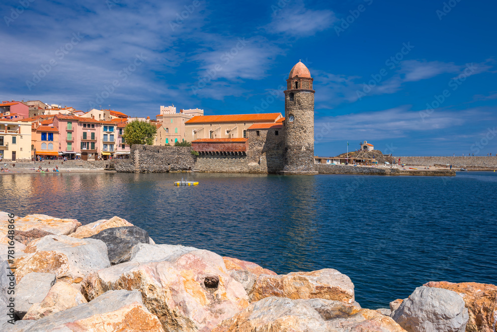 The lighthouse with clocks and the stones on the foreground - Collioure, France The lighthouse with clocks and the stones on the foreground - Collioure, France